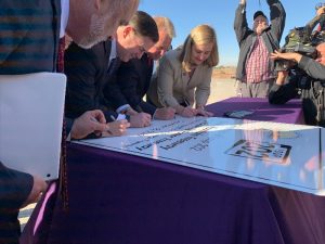 Gov. Doug Ducey, Tempe Mayor Mark Mitchell and Phoenix Mayor Kate Gallego autograph a sign commemorating the new Loop 202 South Mountain Freeway. (Arizona Governor's Office)